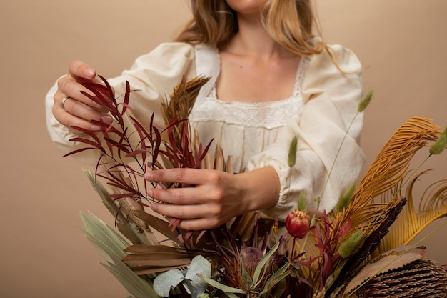 Vista frontal mujer con plantas secas