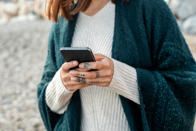 Foto gratuita vista frontal de la mujer en la playa con smartphone