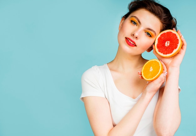 Vista frontal de la mujer con pomelo y naranja