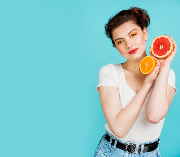 Vista frontal de la mujer con pomelo y naranja