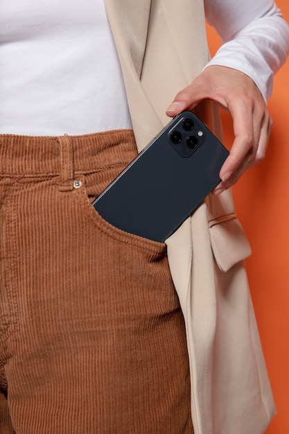 Vista frontal de la mujer poniendo o sacando su teléfono inteligente de su bolsillo