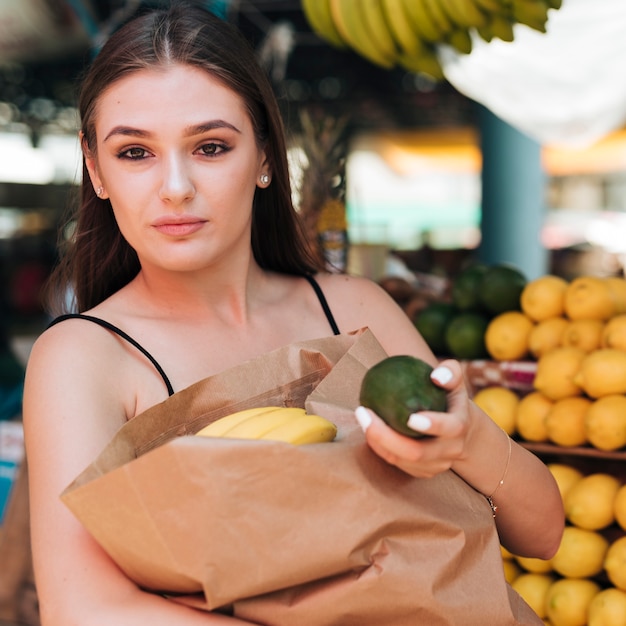 Foto gratuita vista frontal mujer posando con un aguacate