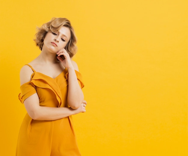 Vista frontal de la mujer posando con copia espacio y traje amarillo