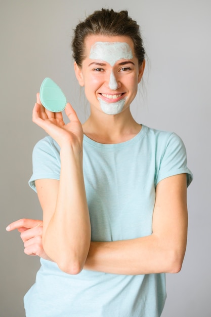 Vista frontal de la mujer posando con crema para la cara