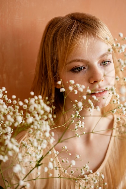 Vista frontal de la mujer posando con delicadas flores