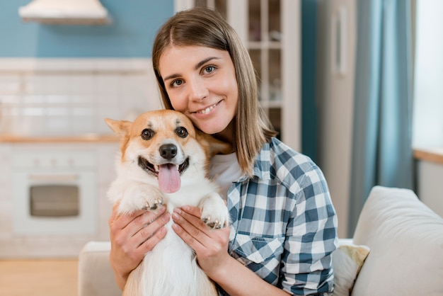 Vista frontal de la mujer posando felizmente con su perro