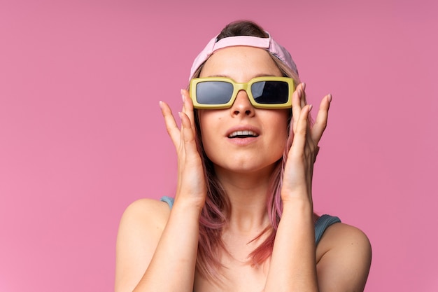 Foto gratuita vista frontal mujer posando con gafas de sol