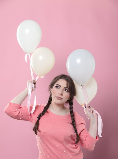 Vista frontal de la mujer posando con globos