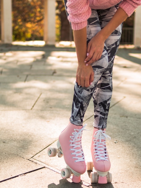 Vista frontal de la mujer posando en legging con patines