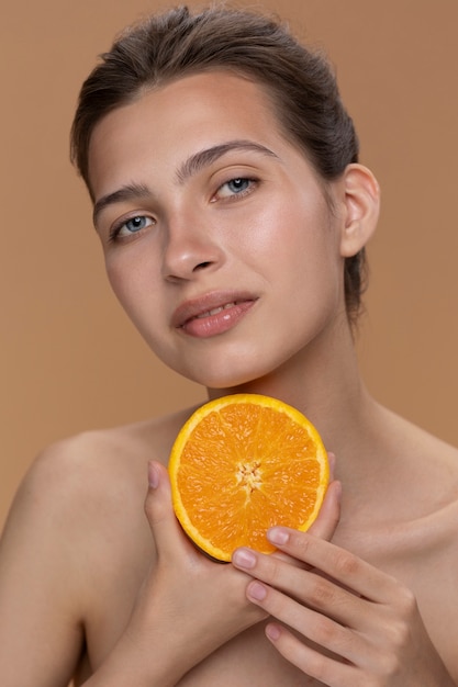 Foto gratuita vista frontal mujer posando con naranja