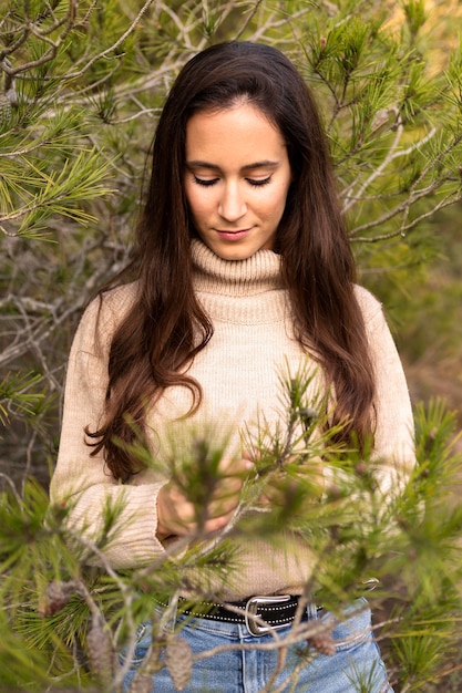 Foto gratuita vista frontal de la mujer posando en la naturaleza con árbol