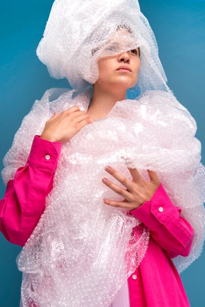 Foto gratuita vista frontal mujer posando con plástico de burbujas