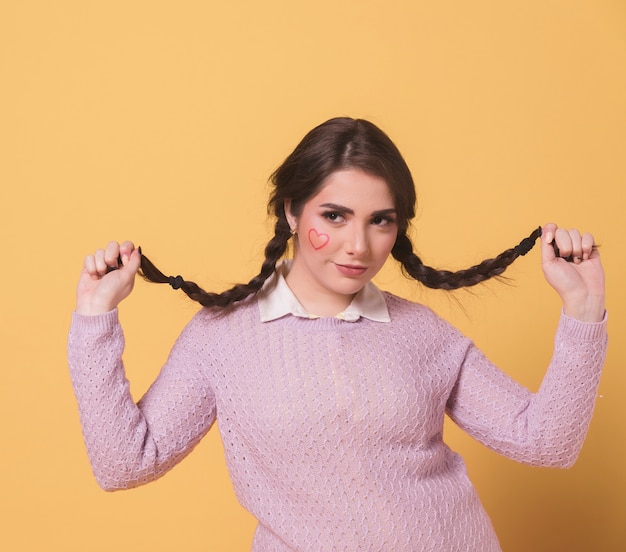 Foto gratuita vista frontal de la mujer posando con sus coletas