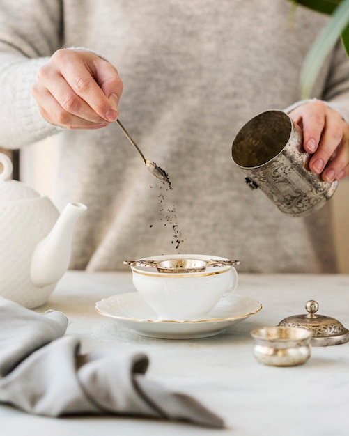 Vista frontal de la mujer preparando té de hierbas