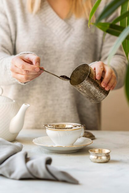 Vista frontal de la mujer preparando té