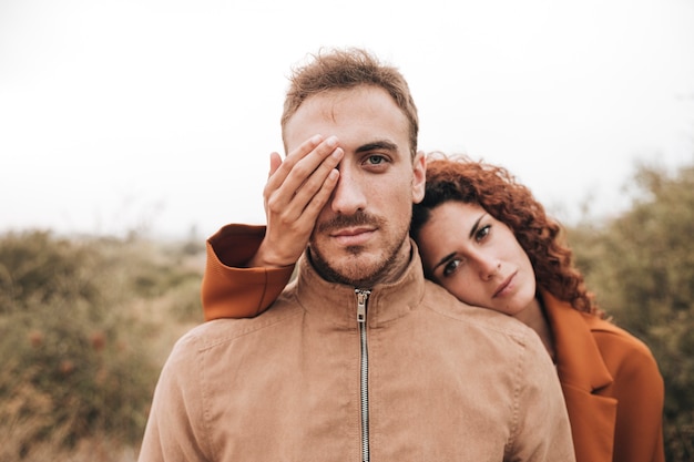 Vista frontal mujer que cubre el ojo del hombre