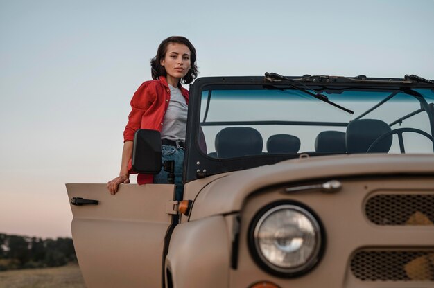 Vista frontal de la mujer que se divierte viajando sola en coche