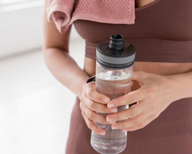 Vista frontal de la mujer que sostiene la botella de agua