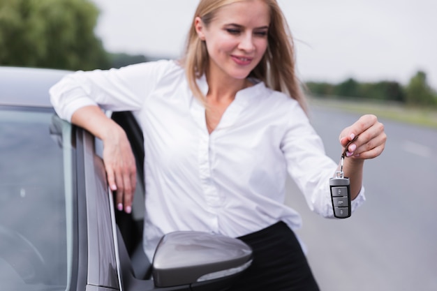 Vista frontal de la mujer que sostiene las llaves del coche