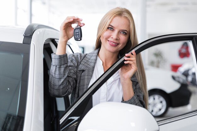 Vista frontal de la mujer que sostiene las llaves del coche