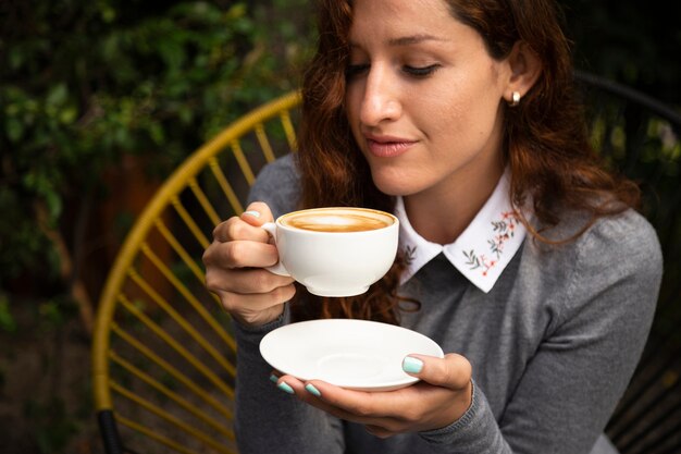 Vista frontal de la mujer que sostiene la taza de café