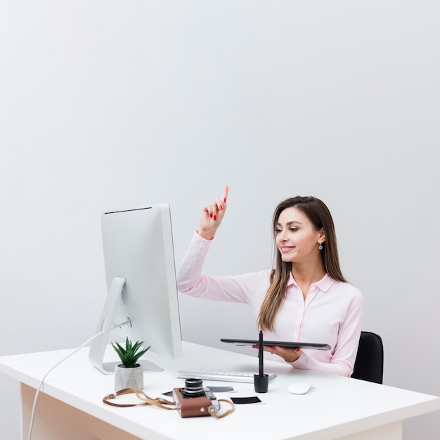 Vista frontal de la mujer que tiene una idea mientras trabajaba en su escritorio