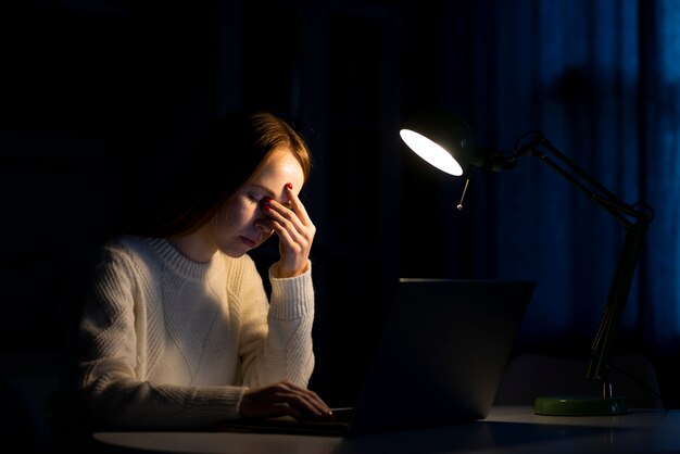 Vista frontal de la mujer que trabaja en la computadora portátil