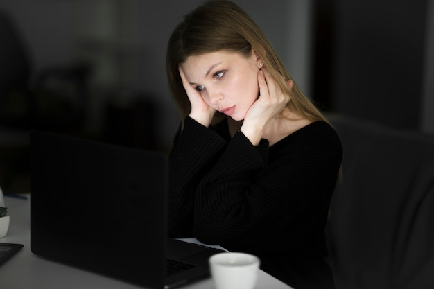 Vista frontal de la mujer que trabaja en la computadora portátil