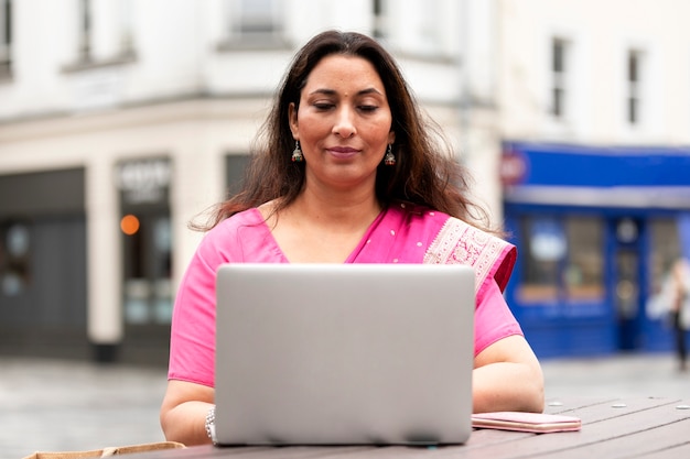 Vista frontal mujer que trabaja en la computadora portátil