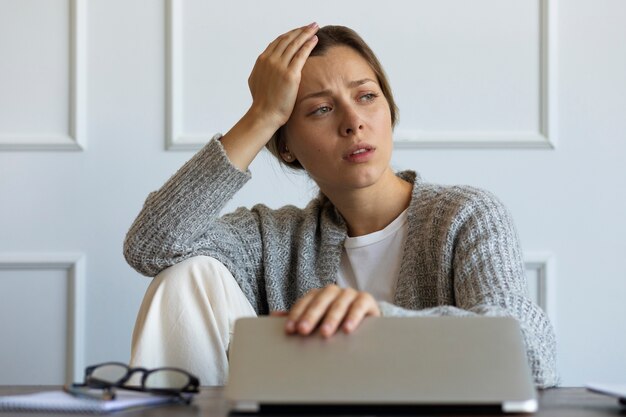 Vista frontal mujer que trabaja en la computadora portátil