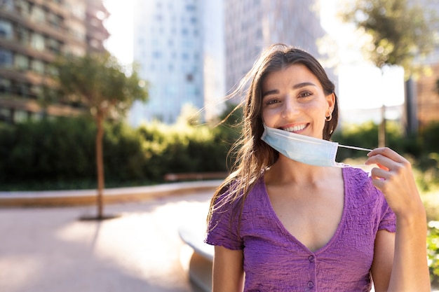 Foto gratuita vista frontal mujer quitándose la máscara