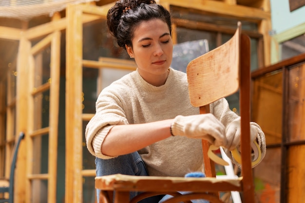 Foto gratuita vista frontal mujer restaurando muebles de madera.