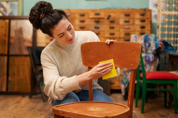 Vista frontal mujer restaurando silla de madera