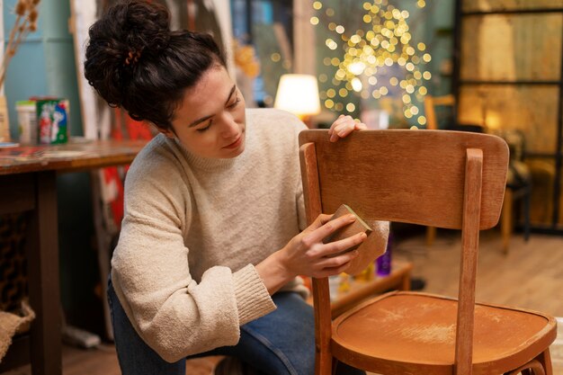 Vista frontal mujer restaurando silla de madera