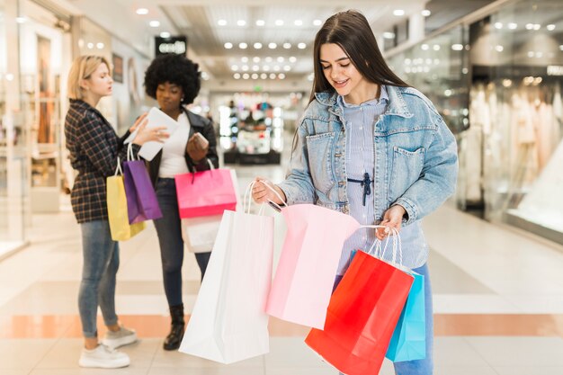 Vista frontal mujer revisando sus bolsas de compras