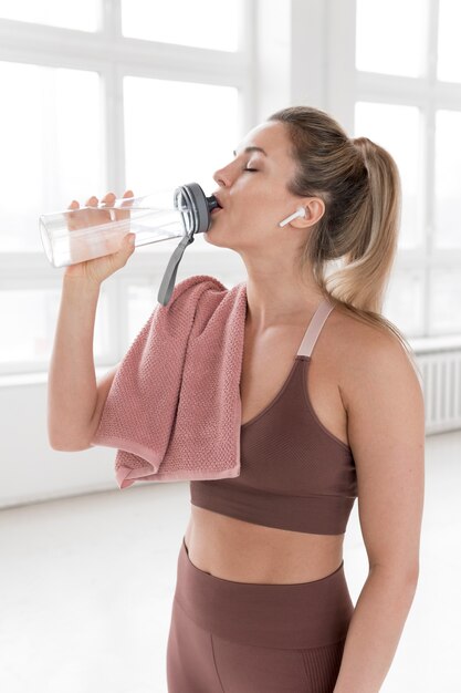 Vista frontal de la mujer rubia agua potable