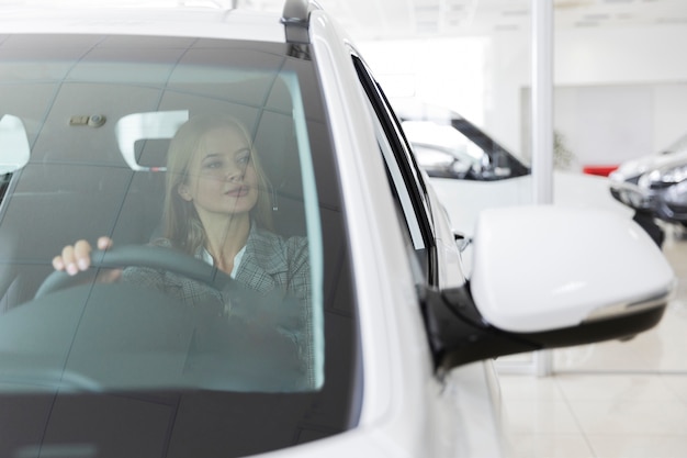 Vista frontal de una mujer rubia en el auto