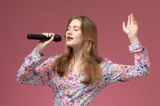 Foto gratuita vista frontal mujer rubia cantando una canción por su corazón