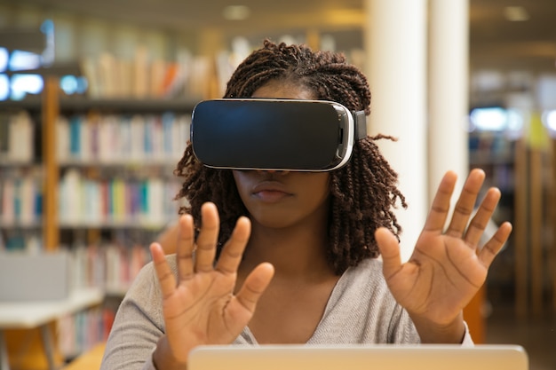 Foto gratuita vista frontal de una mujer seria con gafas de realidad virtual