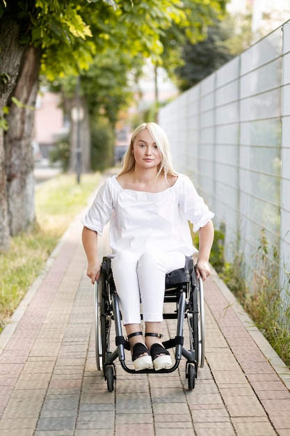 Vista frontal de la mujer en silla de ruedas en la ciudad