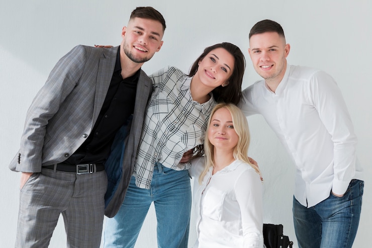 Foto gratuito vista frontal de la mujer en silla de ruedas posando con sus compañeros de trabajo