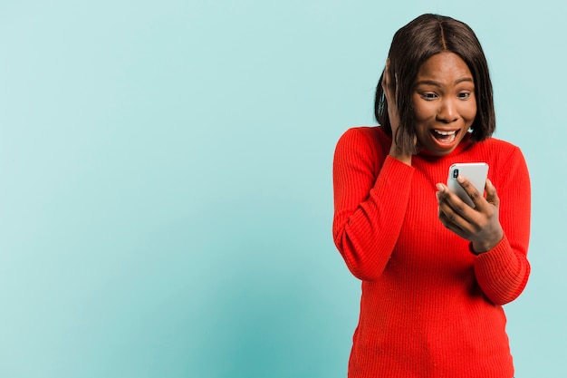 Vista frontal mujer con smartphone en estudio