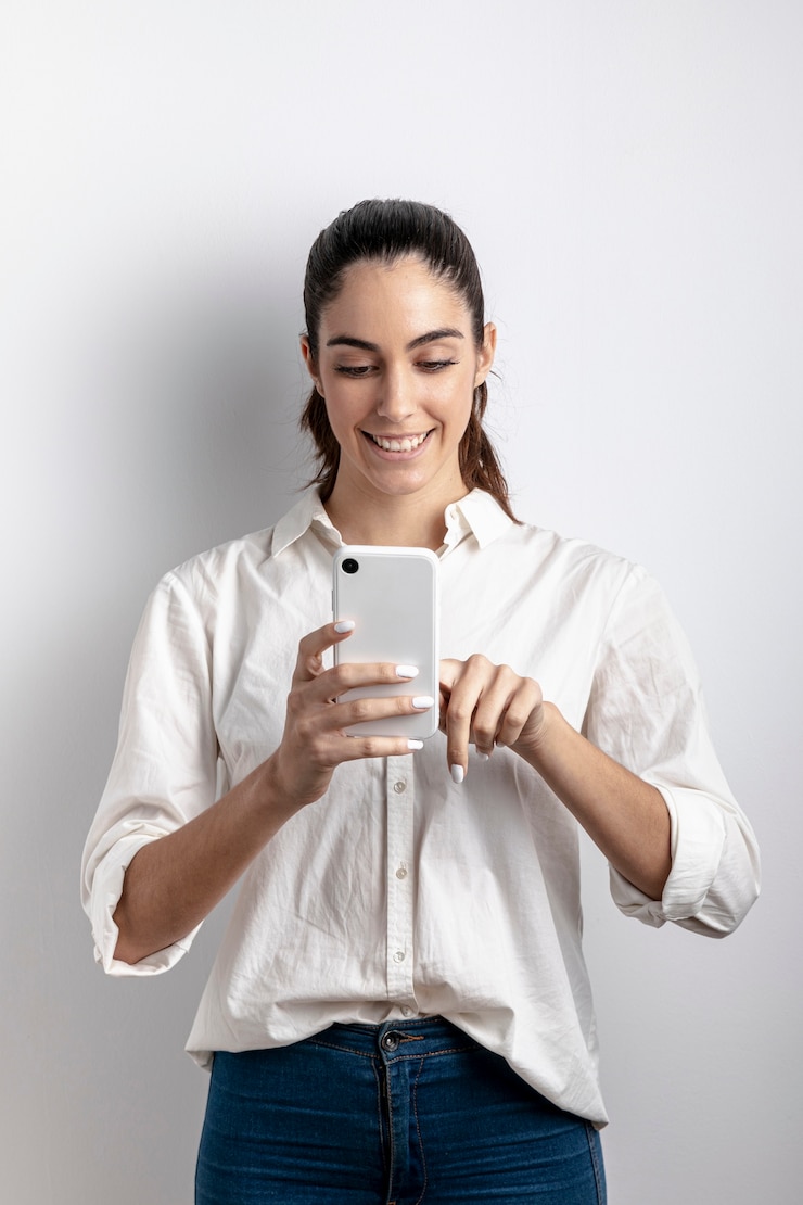 Foto gratuito vista frontal de la mujer sonriendo y sosteniendo el teléfono inteligente