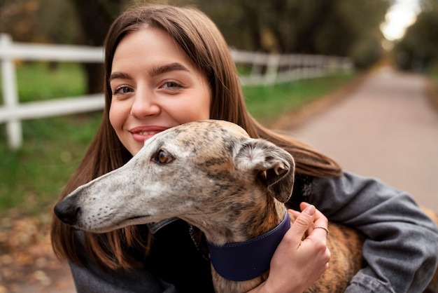 Vista frontal mujer sonriente abrazando perro