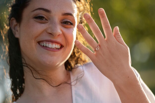 Vista frontal mujer sonriente con anillo de compromiso