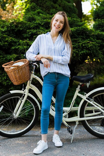 Vista frontal mujer sonriente con bicicleta
