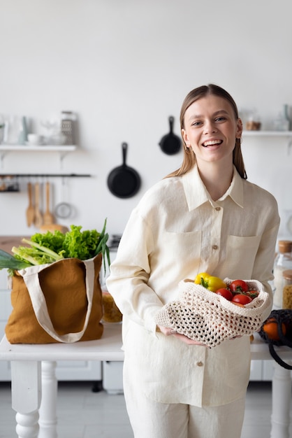 Vista frontal mujer sonriente con bolsa de verduras