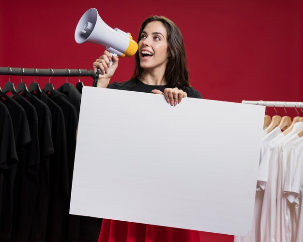 Vista frontal mujer sonriente en compras gritando con un megáfono