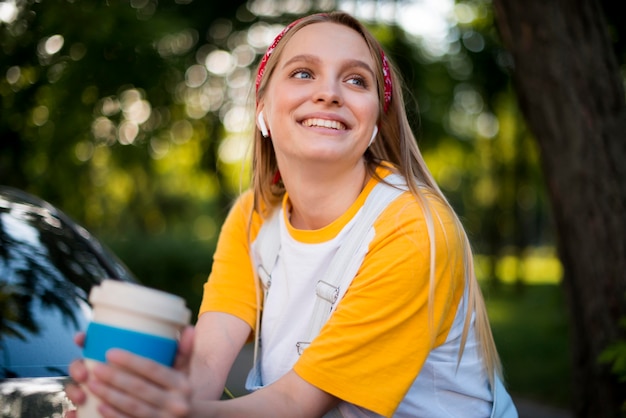 Vista frontal de la mujer sonriente con copa y auriculares