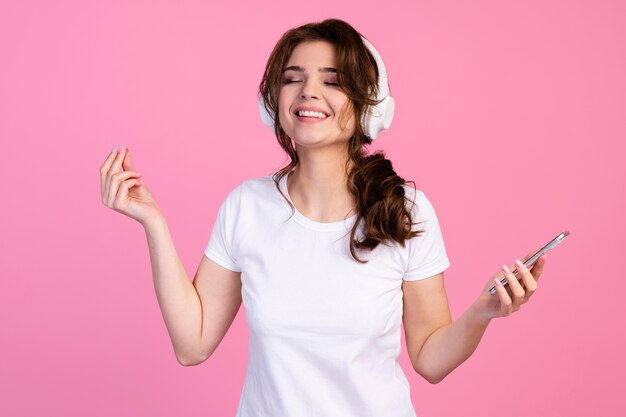 Vista frontal de la mujer sonriente escuchando música con auriculares